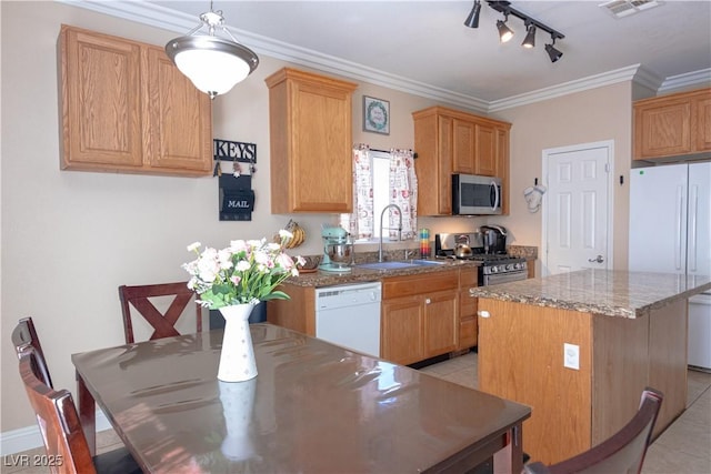 kitchen with stainless steel appliances, a kitchen island, a sink, visible vents, and ornamental molding