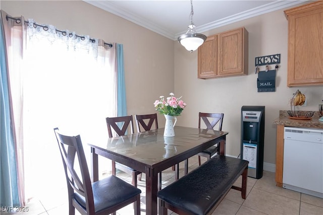 dining room featuring baseboards, ornamental molding, and light tile patterned flooring