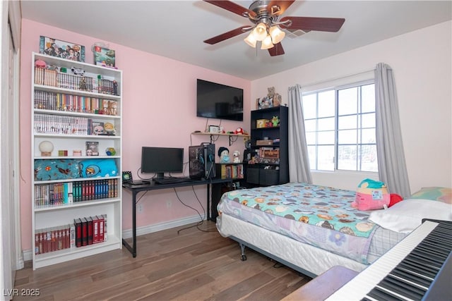 bedroom with wood finished floors, a ceiling fan, and baseboards