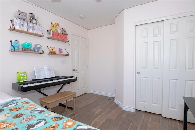 bedroom featuring a closet, baseboards, and wood finished floors