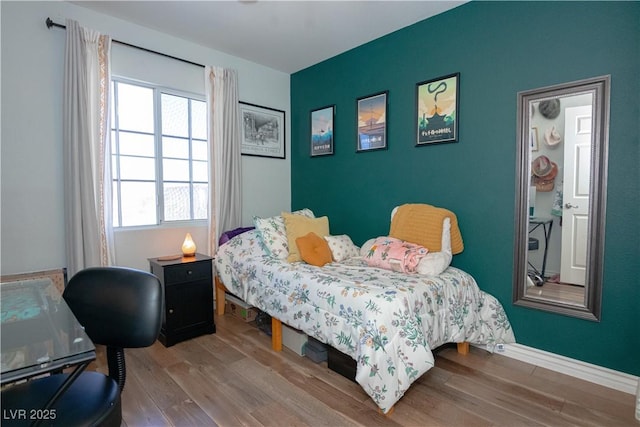 bedroom featuring baseboards and wood finished floors