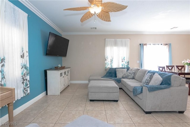 living room with light tile patterned floors, baseboards, visible vents, a ceiling fan, and crown molding