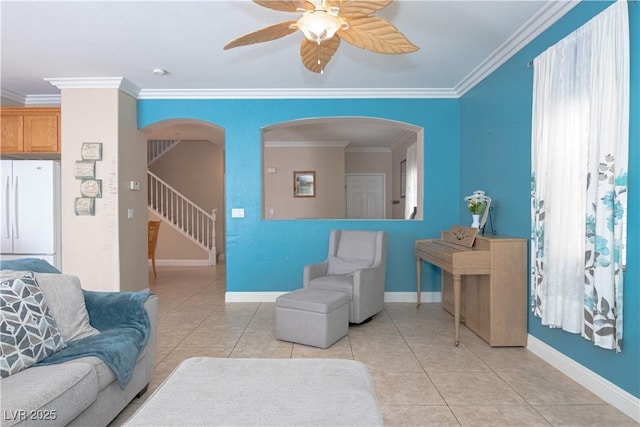 living room featuring arched walkways, ceiling fan, light tile patterned floors, and crown molding