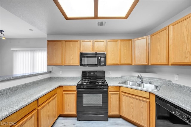 kitchen with a sink, visible vents, light countertops, light brown cabinetry, and black appliances