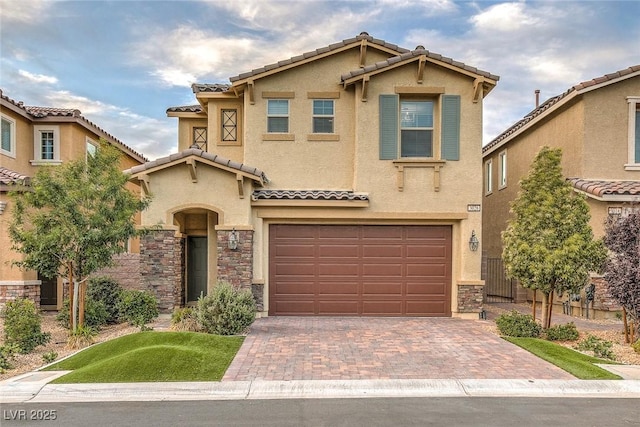 view of front of home with decorative driveway, a tile roof, stucco siding, a garage, and stone siding