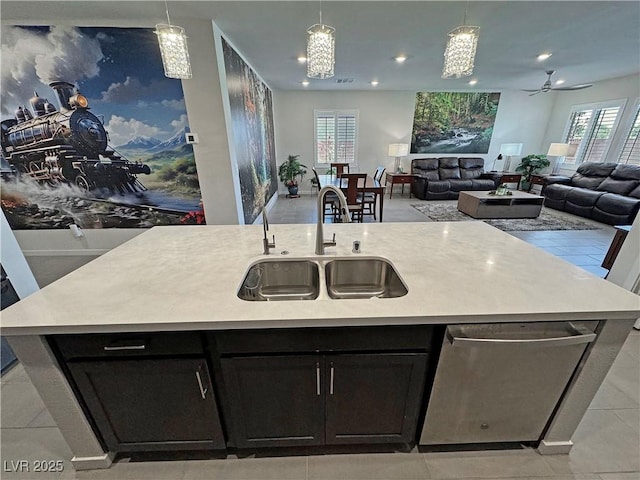 kitchen featuring a center island with sink, open floor plan, a sink, light countertops, and stainless steel dishwasher