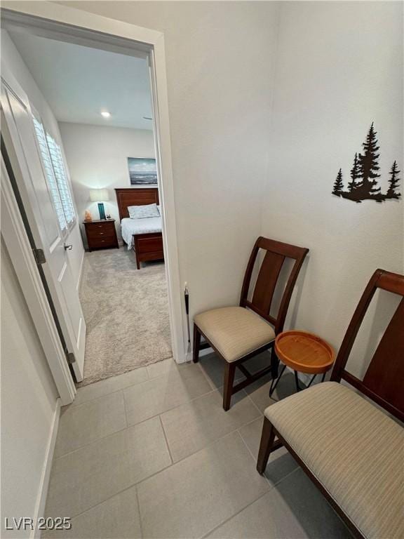 interior space with light carpet, baseboards, and light tile patterned floors