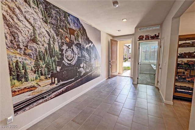 tiled foyer with visible vents and baseboards