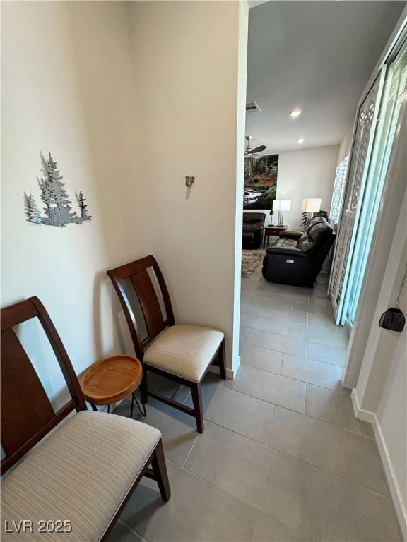 sitting room featuring ceiling fan, visible vents, baseboards, and light tile patterned flooring