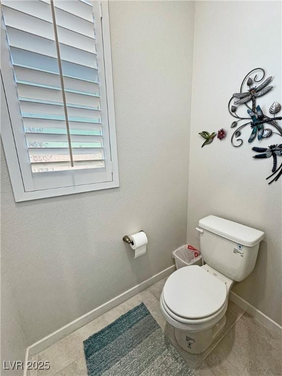 bathroom with baseboards and toilet