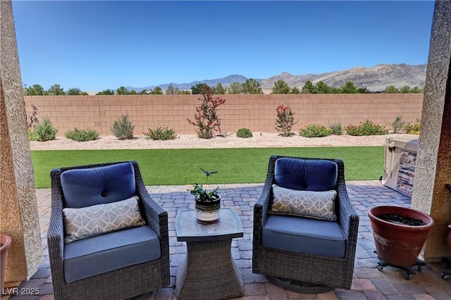 view of patio / terrace with a fenced backyard and a mountain view