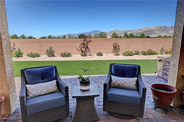 view of patio / terrace featuring a mountain view and a fenced backyard