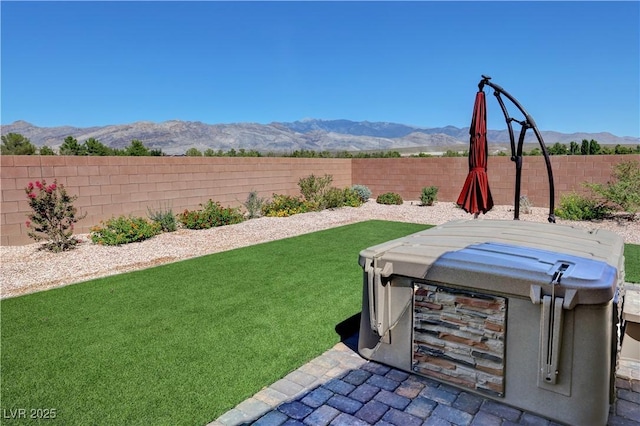 view of yard with a fenced backyard and a mountain view