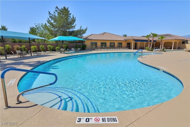 community pool with fence and a patio