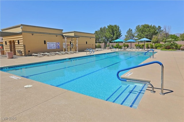 community pool with fence and a patio