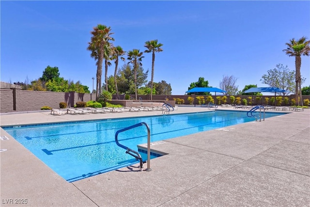 community pool with fence and a patio area