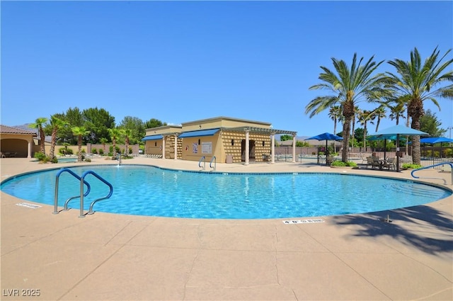 pool featuring fence and a patio area