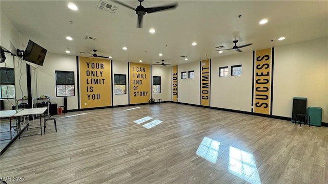 exercise area featuring visible vents, wood finished floors, and ceiling fan