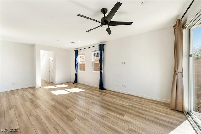 spare room with a wealth of natural light, light wood-style flooring, and baseboards