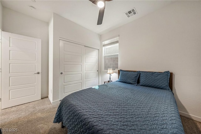 carpeted bedroom featuring a ceiling fan, baseboards, visible vents, and a closet