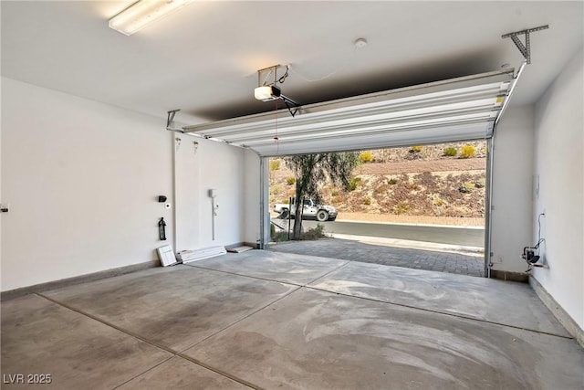 garage with a garage door opener and baseboards