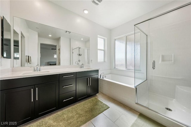 full bathroom featuring a stall shower, a garden tub, a sink, and double vanity