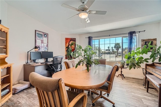 dining room featuring light wood-style flooring, baseboards, and ceiling fan