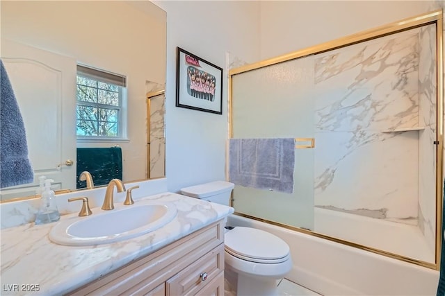 bathroom with combined bath / shower with glass door, vanity, and toilet