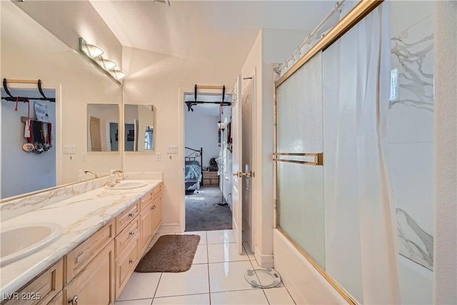 ensuite bathroom with shower / bath combination with glass door, double vanity, connected bathroom, a sink, and tile patterned floors