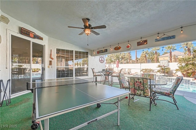 playroom featuring a textured ceiling, carpet floors, vaulted ceiling, and ceiling fan