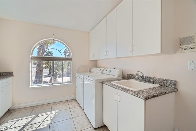 laundry area with cabinet space, light tile patterned floors, baseboards, washing machine and dryer, and a sink