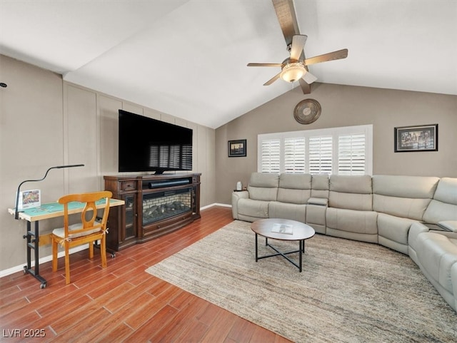 living area featuring lofted ceiling with beams, wood finished floors, a ceiling fan, and baseboards