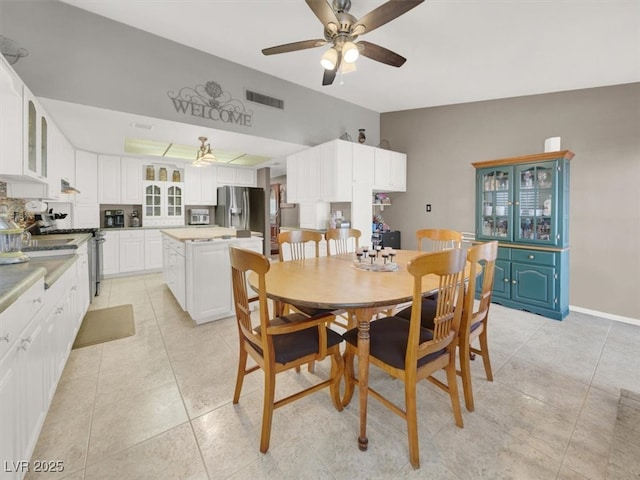 dining space with light tile patterned floors, baseboards, visible vents, and a ceiling fan