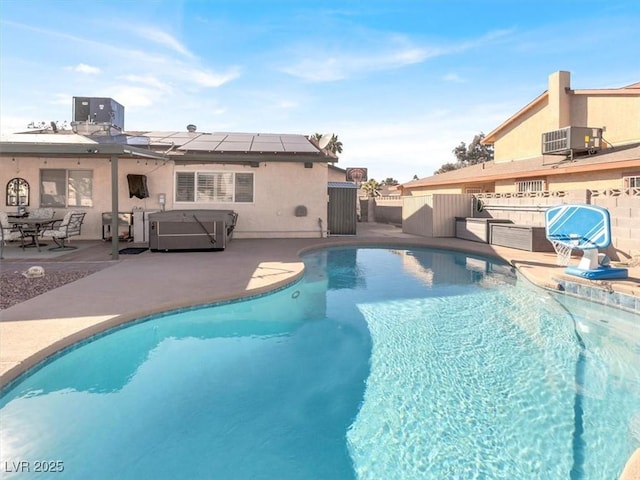 pool featuring a hot tub, fence, cooling unit, and a patio