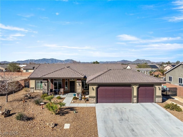 view of front of home featuring an attached garage, a tiled roof, stone siding, driveway, and stucco siding