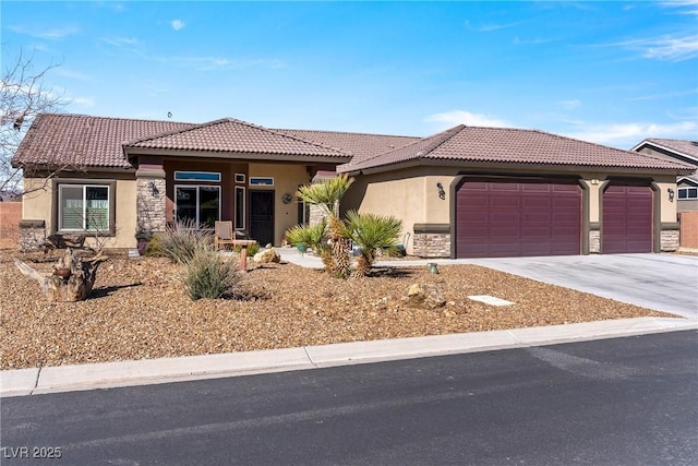 view of front of house with a garage, concrete driveway, stone siding, a tiled roof, and stucco siding