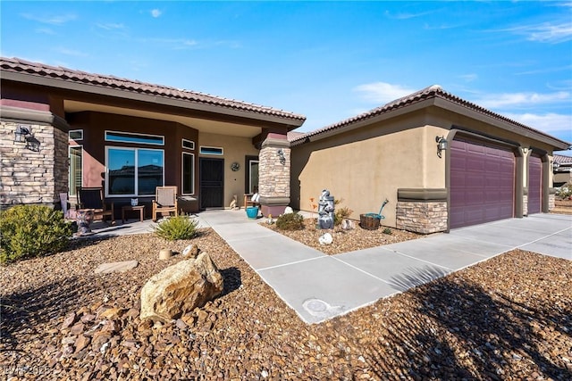 view of front of home featuring stone siding, covered porch, an attached garage, and stucco siding