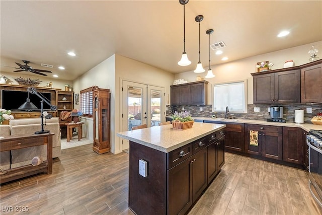 kitchen featuring french doors, backsplash, dark brown cabinets, and wood finished floors