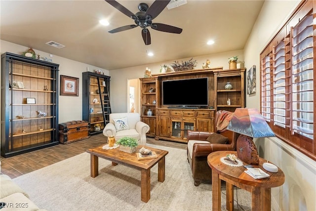 living area with recessed lighting, visible vents, ceiling fan, and wood finished floors