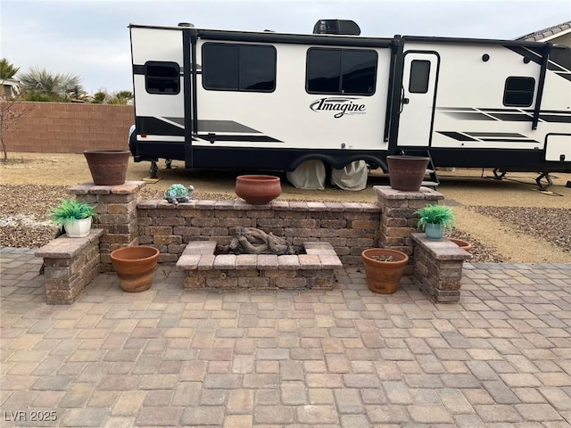 view of patio / terrace featuring an outdoor fire pit and fence