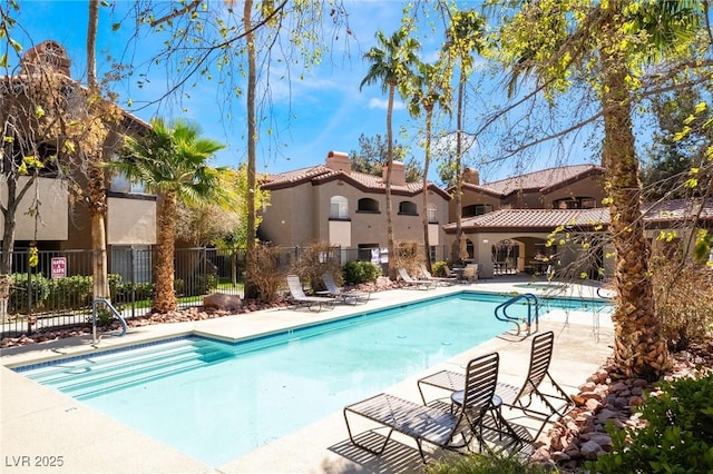 pool with a patio area and fence