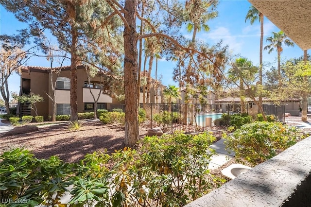 view of community with fence and a swimming pool