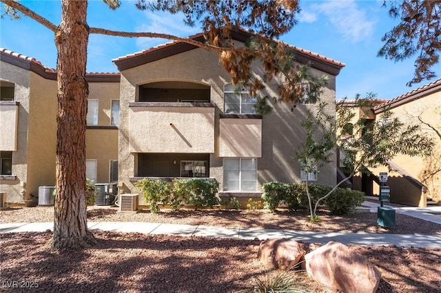 exterior space with central air condition unit, a balcony, and stucco siding