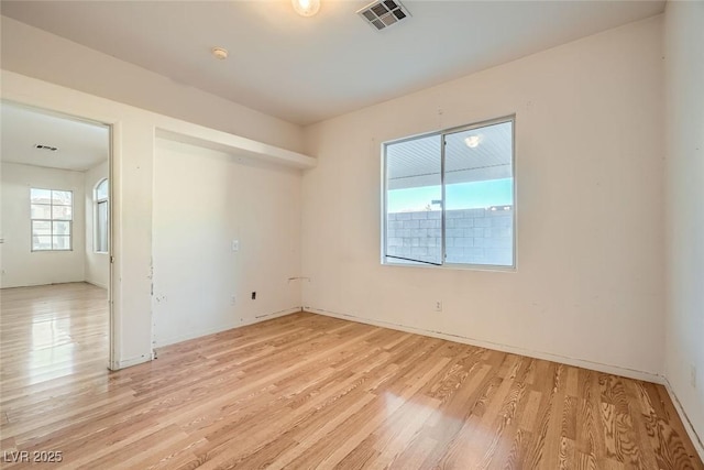 empty room featuring visible vents and light wood-style floors