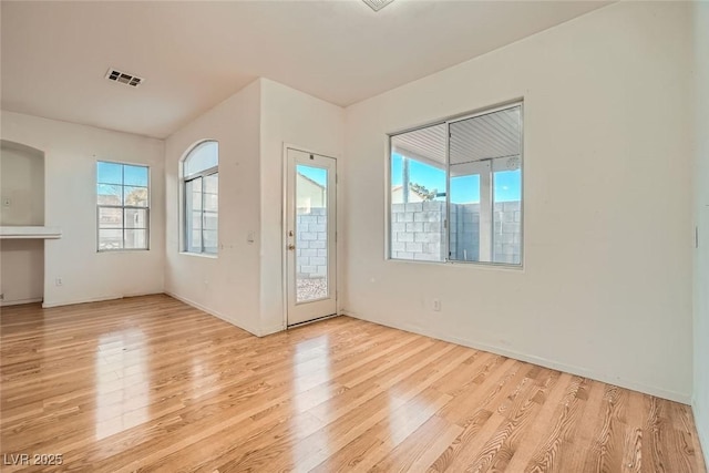 doorway featuring wood finished floors, visible vents, and a healthy amount of sunlight