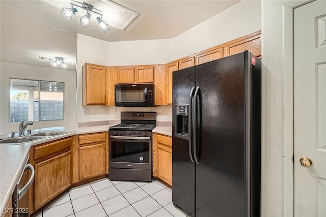 kitchen featuring light tile patterned floors, a sink, light countertops, black appliances, and brown cabinetry