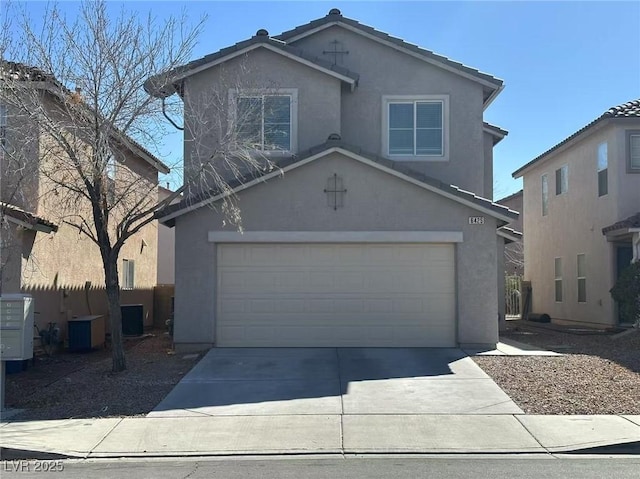 traditional-style home with driveway, an attached garage, a tile roof, and stucco siding