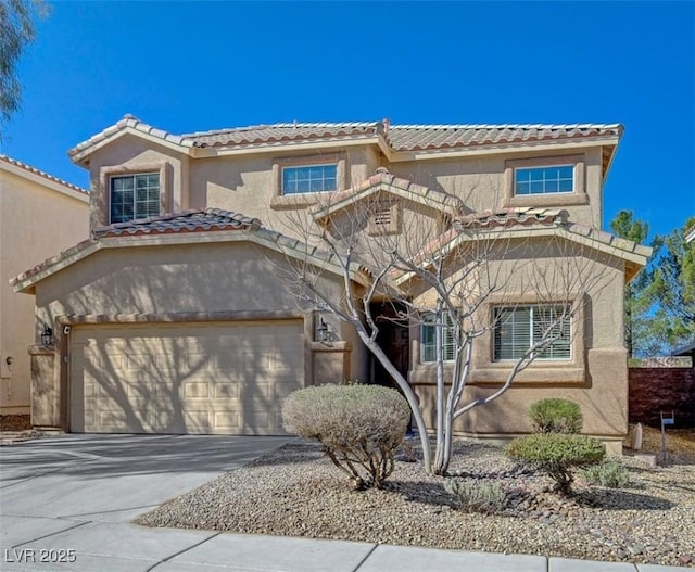 mediterranean / spanish-style home with a garage, concrete driveway, a tiled roof, and stucco siding