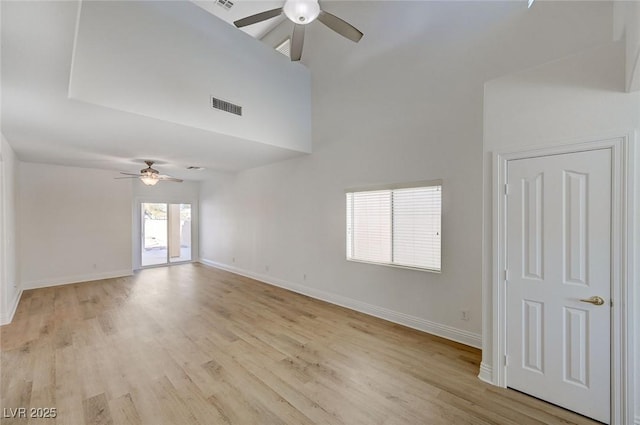 empty room with a ceiling fan, baseboards, visible vents, and light wood finished floors