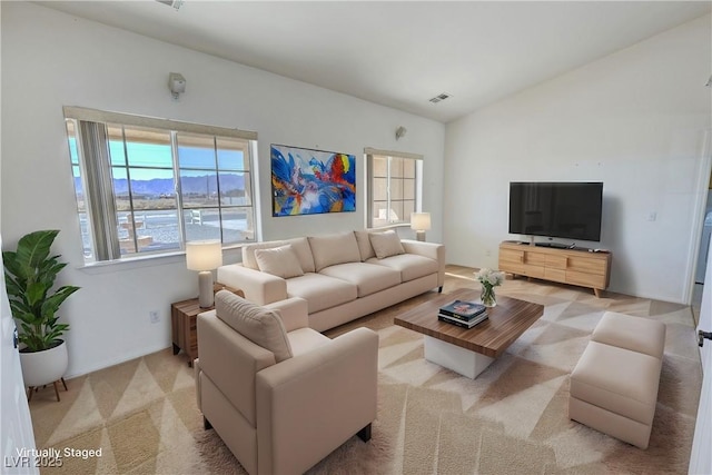 living area featuring carpet floors, visible vents, and vaulted ceiling